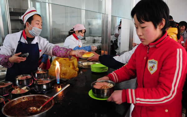 Students get their lunch at a standardized school canteen in Ganzhou district, Zhangye city of Gansu province on Dec 6. Standardized school canteens offer safe lunch