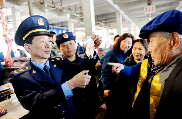 Officials from the industry and commerce administration in Dexing, Jiangxi province, introduce methods to tell if water has been injected into meat, during an activity on Wednesday to mark World Consumer Rights Day, which falls on Friday. ZHUO ZHONGWEI / FOR CHINA DAILY High hopes for new food safety monitoring