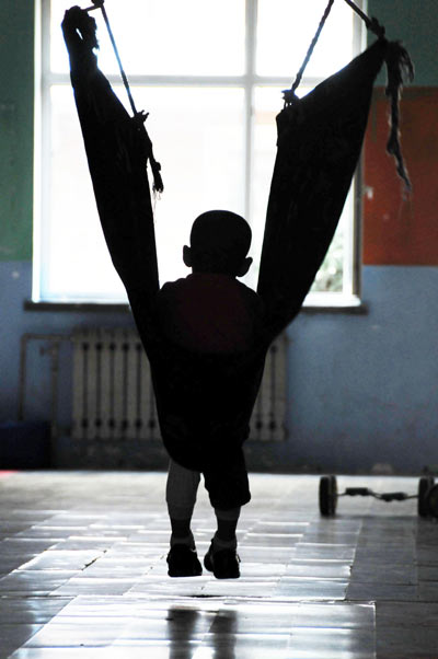 A child practises a training program in a rehabilitation center in Harbin city, Northeast China's Heilongjiang provine on March 28, 2013. Caring for autistic children