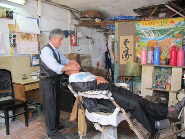 A traditional shave in the ancient town. Xu Xiaomin / China Daily Relief from the madding crowds