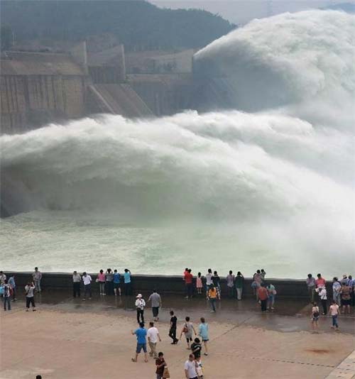 Tourists watch as water gushing out of the Xiaolangdi Reservoir on the Yellow River during a water and sediment regulating operation in Sanmenxia city of Central China's Henan province, June 22, 2013. Water gush out of Xiaolangdi Reservoir