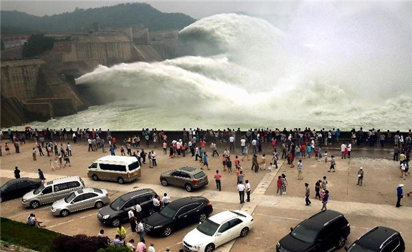 Tourists watch as water gushing out of the Xiaolangdi Reservoir on the Yellow River during a water and sediment regulating operation in Sanmenxia city of Central China's Henan province, June 22, 2013. Water gush out of Xiaolangdi Reservoir