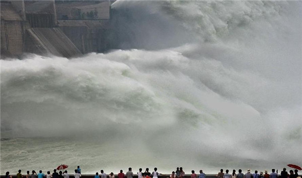 Tourists watch as water gushing out of the Xiaolangdi Reservoir on the Yellow River during a water and sediment regulating operation in Sanmenxia city of Central China's Henan province, June 22, 2013. Water gush out of Xiaolangdi Reservoir
