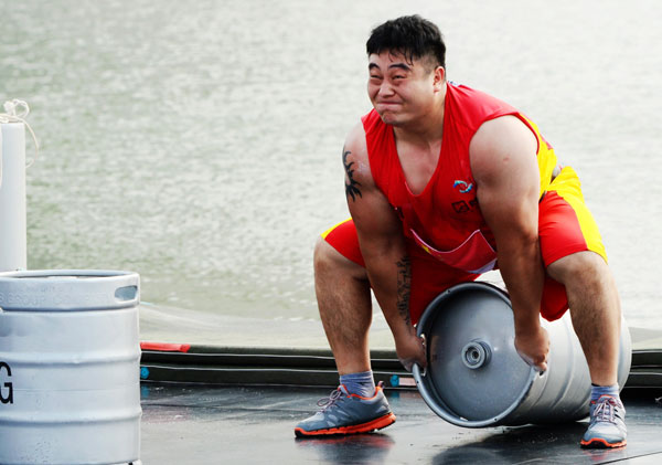 Zhou Rong from China competes in the keg toss event during the World's Strongest Man Competition in Zhengzhou, Henan province, on July 6, 2013. Herculean effort