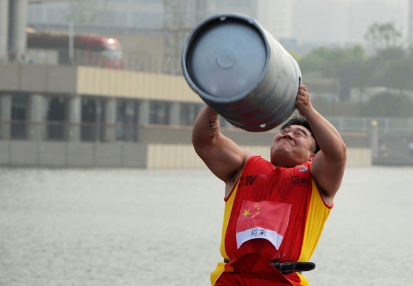 Zhou Rong from China competes in the keg toss event during the World's Strongest Man Competition in Zhengzhou, Henan province, on July 6, 2013. Herculean effort