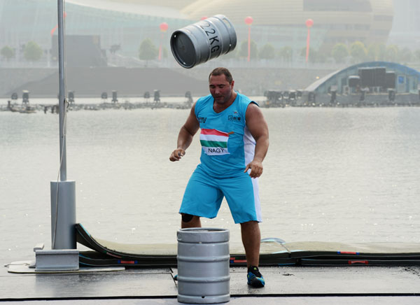 A competitor competes in the keg toss event during the World's Strongest Man Competition in Zhengzhou, Henan province, on July 6, 2013. Herculean effort