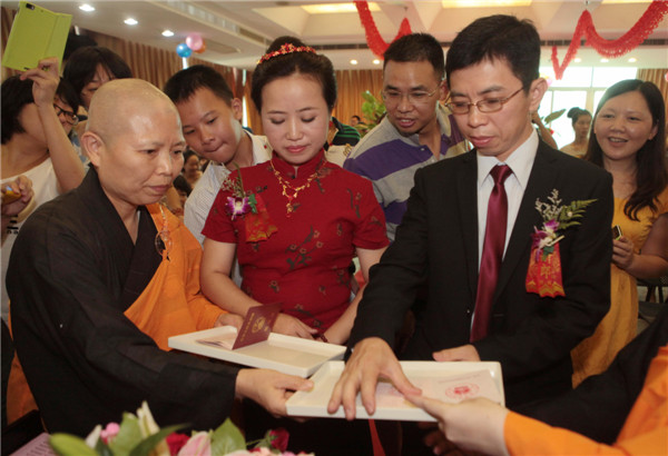 The new couple print their fingers on marriage certificates at their wedding in Xiamen city, Fujian province on July 6, 2013. Buddhist wedding chimes in E China