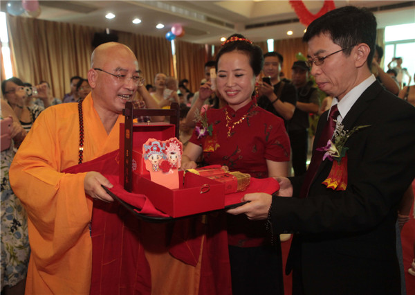 A Buddhist master presents the new couple with gifts at their wedding in Xiamen city, Fujian province on July 6, 2013. Buddhist wedding chimes in E China
