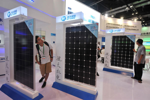 Visitors view solar panels at the 2013 China International Clean Energy Expo in Beijing, July 3, 2013. EU solar trade dispute diffused