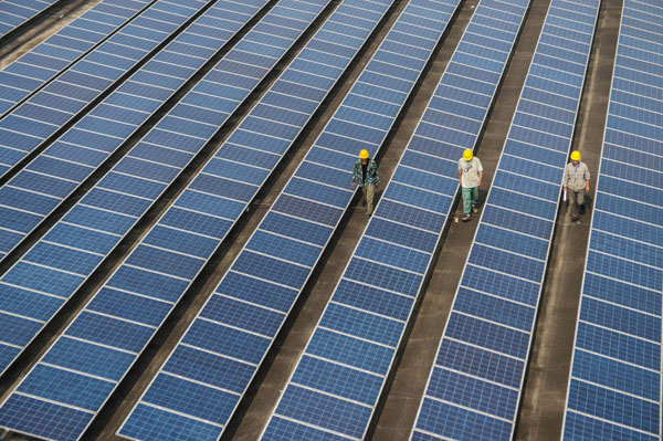 Workers check solar panels at a photovoltaic power station on a factory roof in Changxing county, East China's Zhejiang province, June 5, 2013. EU solar trade dispute diffused