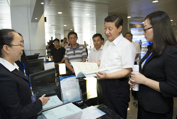 Chinese President Xi Jinping (2nd R), who is also general secretary of the Communist Party of China (CPC) Central Committee, talks with staff members and farmer customers at a rural equity transaction house in Wuhan, capital of Central China's Hubei province, July 22, 2013. Top leader vows to meet target