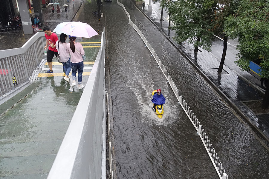 Downpour floods streets in Beijing, turns down summer heat