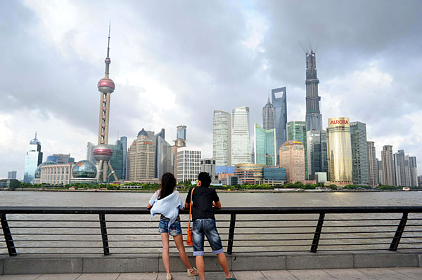 Visitors overlook the Bund area across the Huangpu River in Shanghai, Aug 21, 2013. Guideline made for Shanghai pilot zoneang