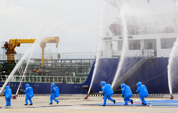 Soldiers in biohazard suits simulate a mock contamination of a ship during the 2011 Jinhua exercise at the Port of Taipei in New Taipei City, northern Taiwan June 29, 2011. Disaster-response drill in Taiwan