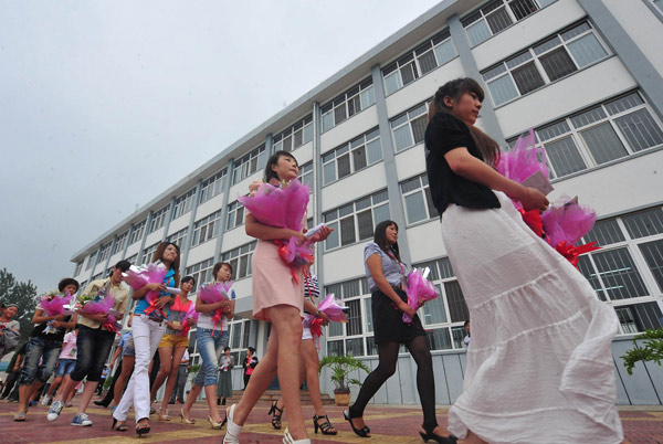 Women walk out of a prison after visiting their fiancés for the upcoming Chinese Valentine's Day, Qixi Festival, which falls on the seventh day of the seventh month on the Chinese lunar calendar, August 6 this year, in Xinyang, Central China's Henan province, August 3, 2011. Celebrating Chinese Valentine's Day behind bars
