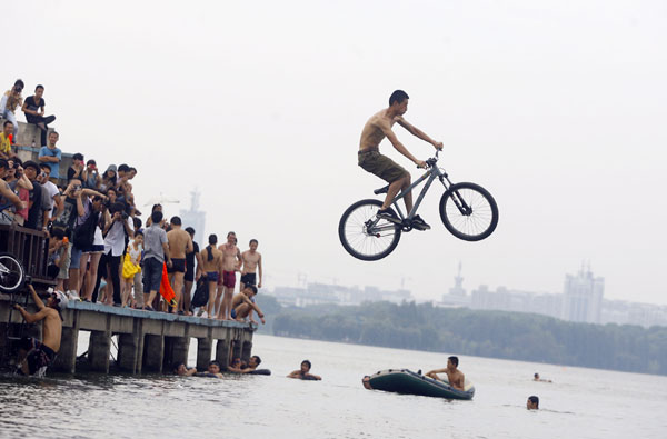 A cyclist jumps into a lake in Wuhan, July 9, 2012. Cyclists dive into lake in C. China