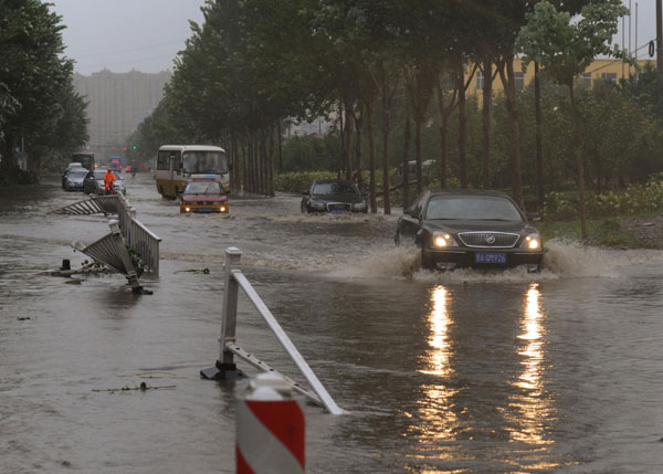 Cars attempt to drive through a flooded street in Changchun, Aug 28, 2012. Deadly storm lashes NE China