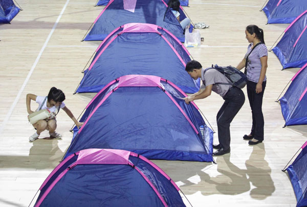 A girl and her parents look at a makeshift tent during her college registration at Tianjin University, Aug 29, 2012. Parents camp out for freshmen