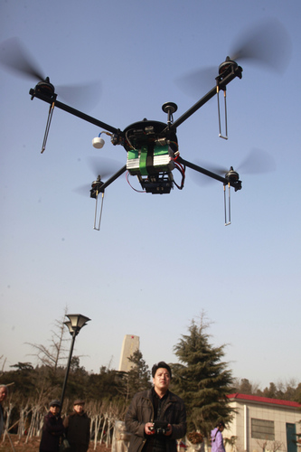 A man controls his homemade remote controlled aerial photography 'spider' during take off at Hero Mountain Park in Jinan, East China's Shandong province, on March 4, 2013. The spider-shaped aircraft attracted the attention of a number of tourists. Mr. Liu, who made the device, said he was very glad his aircraft could fly and be used to take aerial photos of Jinan. [Zheng Tao/Asianewsphoto Homemade aerial photo 'spider' takes off
