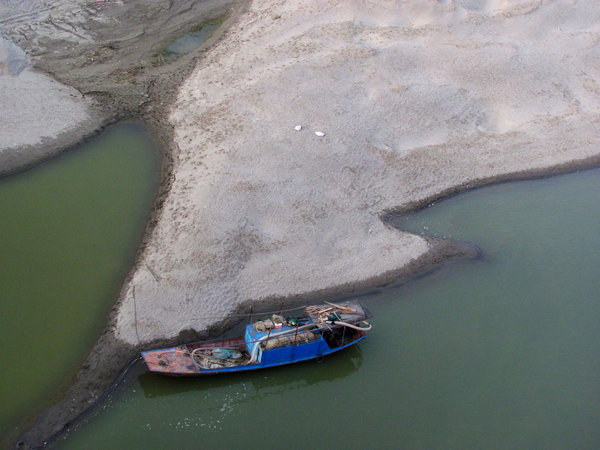 A dried-up river bed is exposed in Yun county, Shiyan city of Central China's Hubei province, April 11, 2013. Scarce rainfall lowers river levels in C China