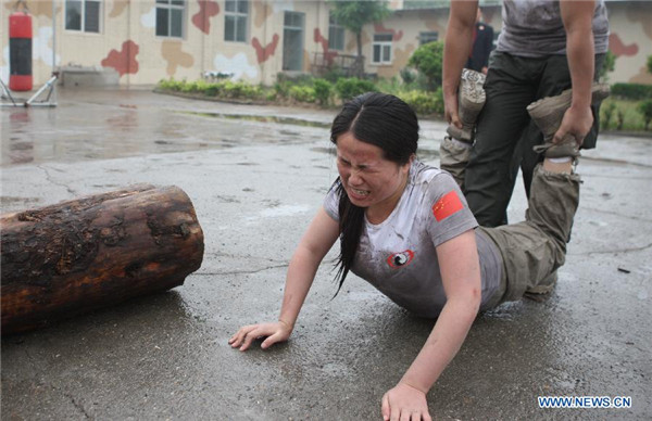 A female trainee reacts during a VIP security training course at the Genghis Security Academy in Beijing, June 6, 2013. Trainees take security training course in Beijing