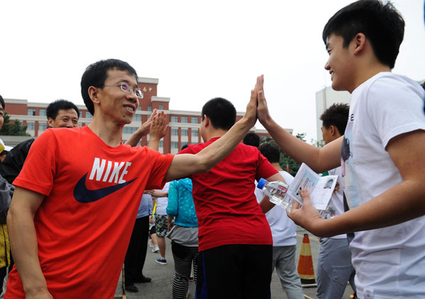 Teachers high-five students outside a test site in Changchun, Northeast China’s Jilin province, June 7, 2013. Big exam day kicks off