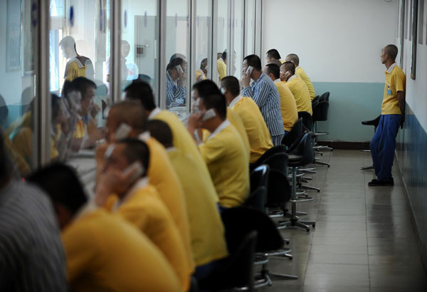 Youngsters recovering from drug addiction talk to their relatives by phone through a glass screen at a rehab center in Shanxi, June 13, 2013. Battling addiction with compulsory detox