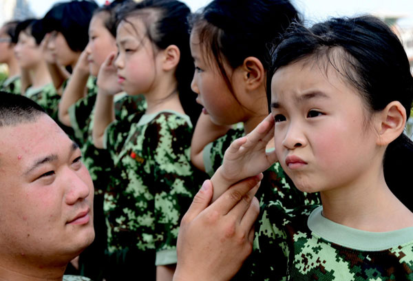 Zheng Yunchu, 7, practices a military salute under instruction in Fuqing on July 29, 2013. Quick march at summer boot camp