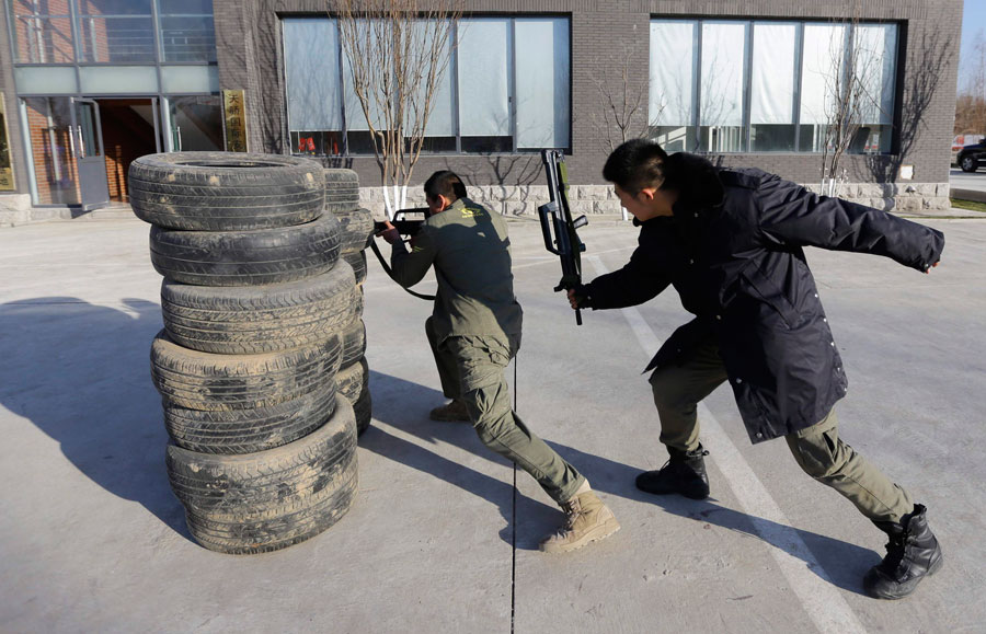 An instructor hits a trainee with a replica 95 semi-automatic rifle during training at the Tianjiao Special Guard/Security Consultant training camp on the outskirts of Beijing December 11, 2013. Bodyguard biz sees big profits