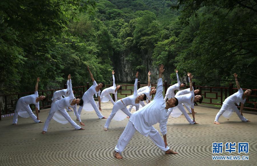 Practicing yoga among green hills and clear water