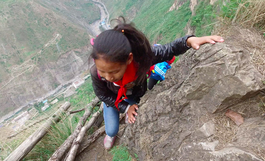 Kids climb vine ladder in 'cliff village' in Sichuan