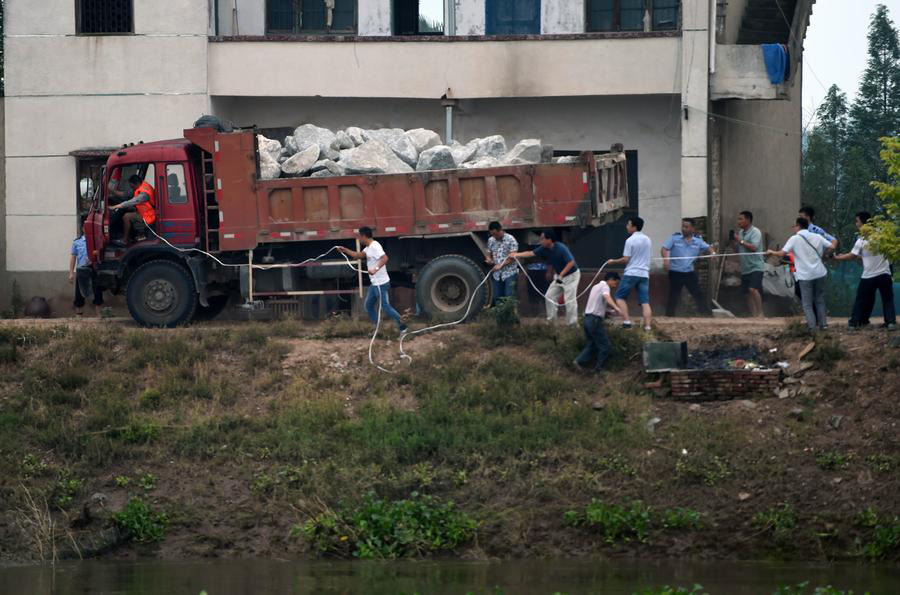 Rescuers risk life, drive heavy trucks to block floodwater