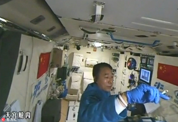 Astronaut plays with silkworms in Tiangong II