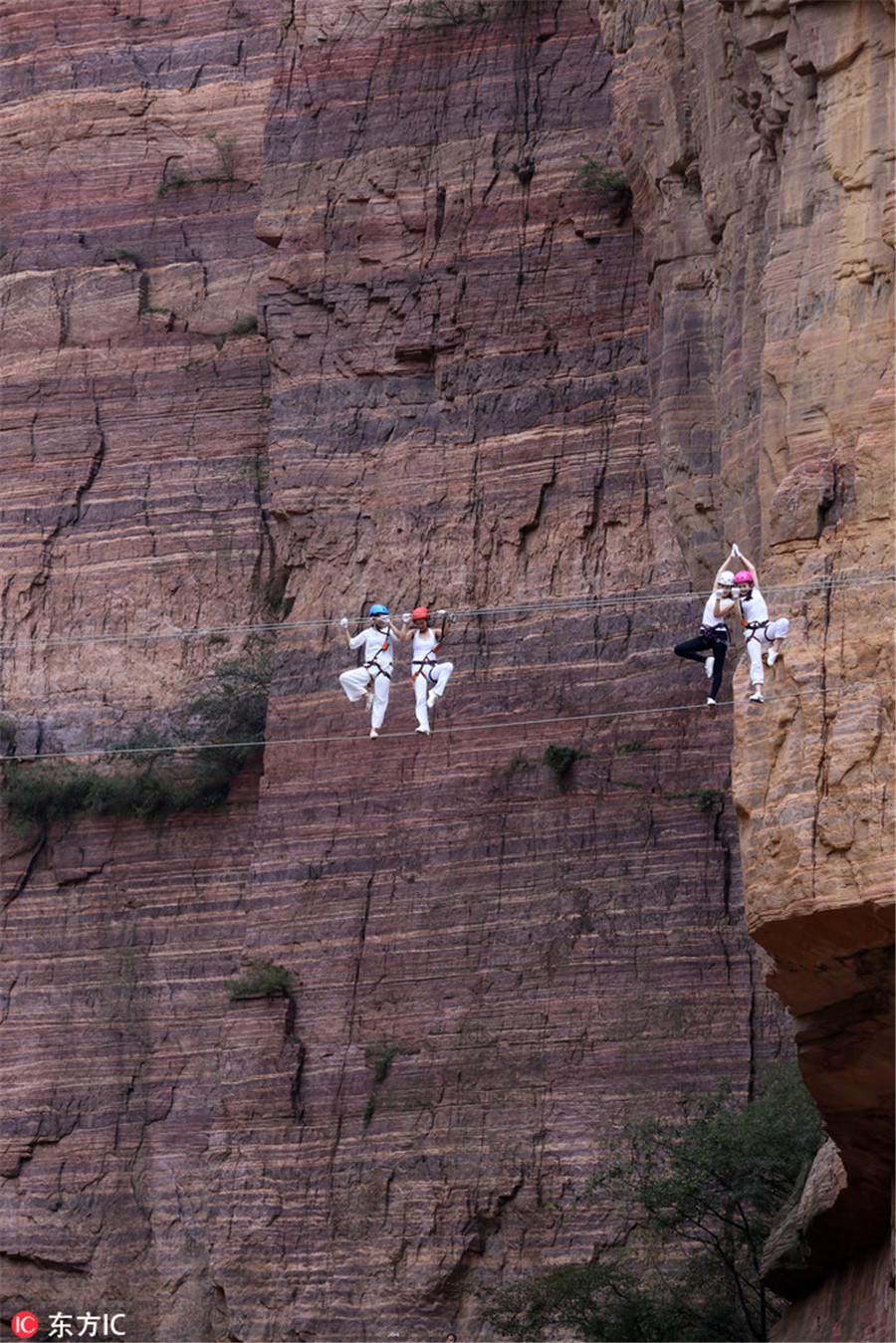 High on mountain: Yoga enthusiasts practice on cliff