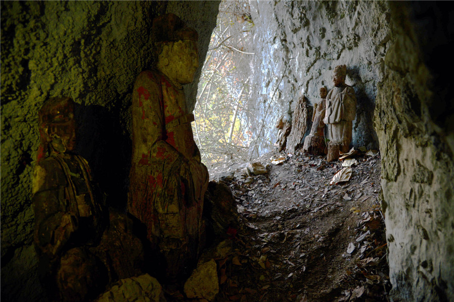 Wood sculptures discovered inside cliffside cave in Chongqing