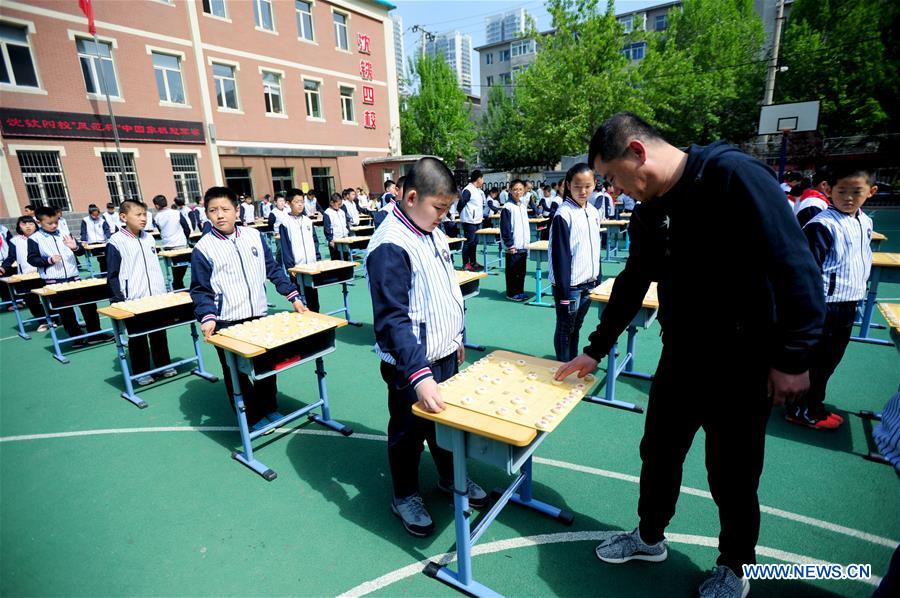 Pupils play Chinese chess during activity in NE China