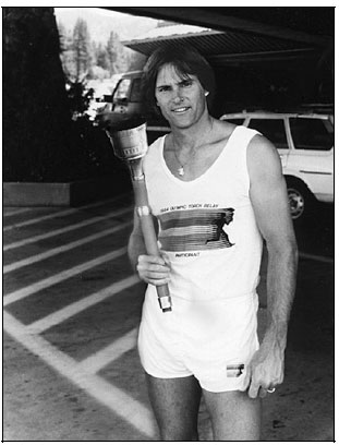 bruce jenner poses with the 1984 olympic torch.