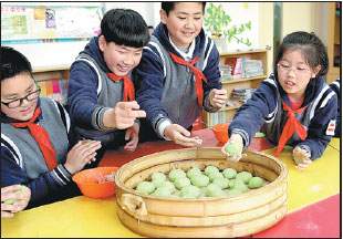 Young Chinese helping sticky rice balls make a comeback