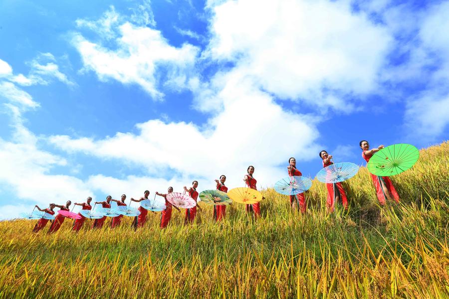 Women present cheongsam at Ping'an terrace field in Guangxi
