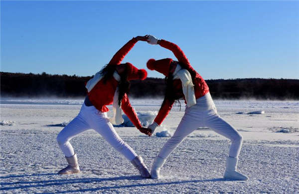 Yoga enthusiasts practice on frozen river in Heilongjiang