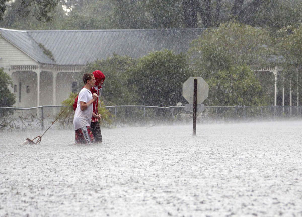Residents of Mandeville walk through a flooded street as Hurricane Isaac passes through Mandeville, Louisiana, August 30, 2012. Isaac's rage in Louisiana