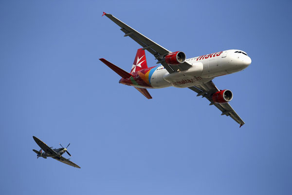 A Second World War-era Supermarine Spitfire (L) from the Old Flying Machine Company, in British Royal Air Force markings, and an Air Malta Airbus A320 airliner fly in formation during the Malta Airshow at Malta International Airport, outside Valletta September 30, 2012. Malta Airshow