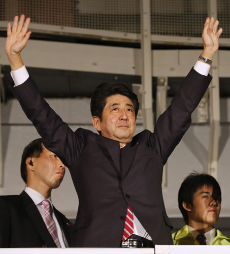 Japan's main opposition Liberal Democratic Party's (LDP) leader and former Prime Minister Shinzo Abe raises his hands atop a campaign van at Akihabara electronics store district in Tokyo, Dec 15, 2012, on the last election campaign day ahead of Sunday's general election. Japan votes in election seen returning LDP to power
