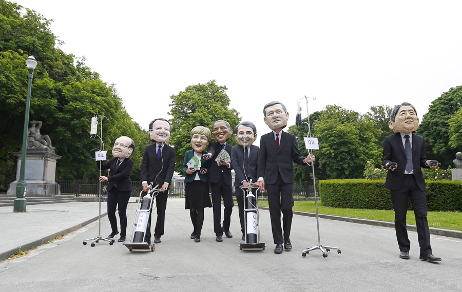 Oxfam demonstrators wearing masks of G7 leaders protest in Brussels