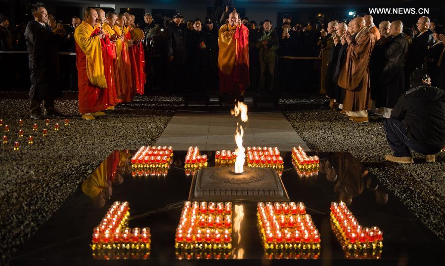 People hold candles to mourn victims of Nanjing Massacre