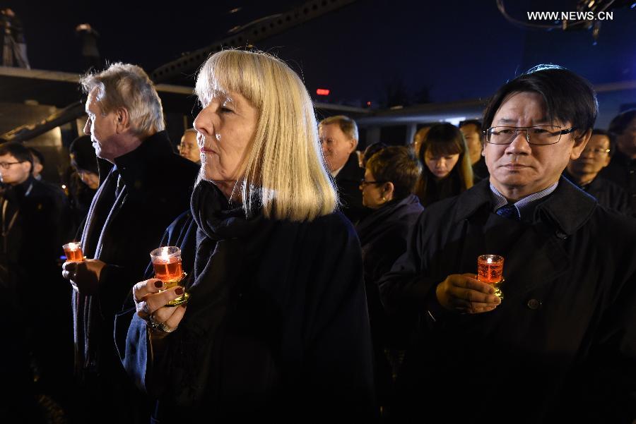 People hold candles to mourn victims of Nanjing Massacre