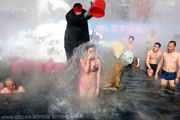 Girls in bikini pour ice in hot spring