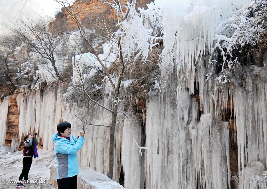 People take photos of frozen waterfalls in N China