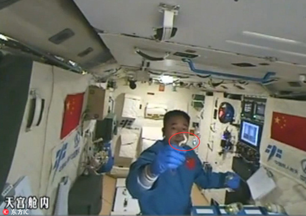 Astronaut plays with silkworms in Tiangong II