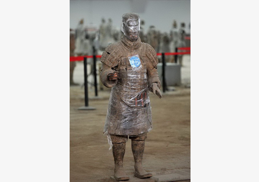 Terracotta warriors wrapped in cling film for protection of remnant painting